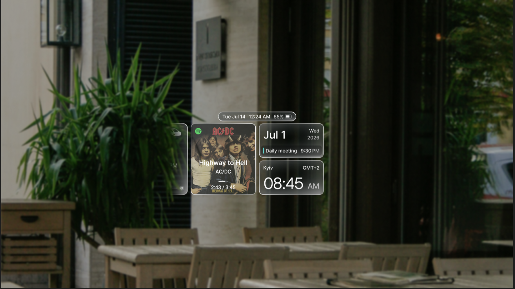 Augmented reality interface displaying music playback, a calendar event, and the current time over an outdoor café scene.
