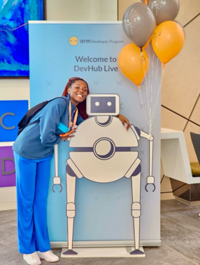 Dominica posing with a robot cutout at DevHub Live