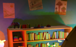 Close-up of a bookshelf lit by multiple colored dynamic lights, showing shadow detail and lighting noise.