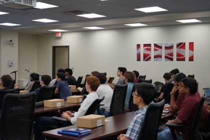 A picture showing the attendees engaged with the presentation.